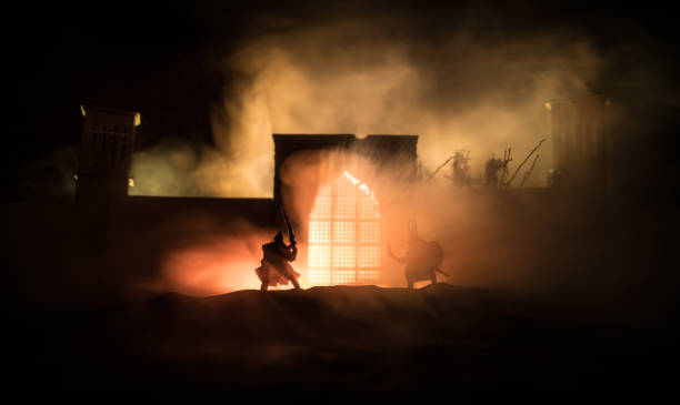 istock Medieval battle scene with cavalry and infantry. Silhouettes of figures as separate objects, fight between warriors on sunset foggy background. 1298207726