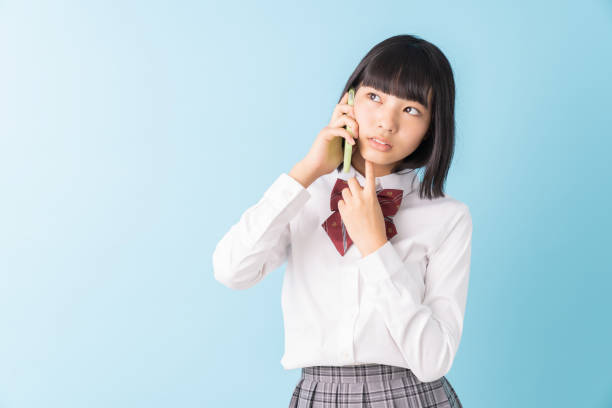 istock girl student who talks on the telephone,School uniform,think, 1298207739