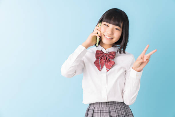 istock girl student who talks on the telephone,School uniform, 1298207787