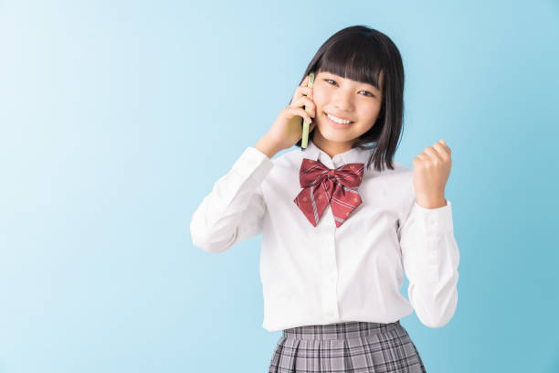 istock girl student who talks on the telephone,School uniform, 1298207812