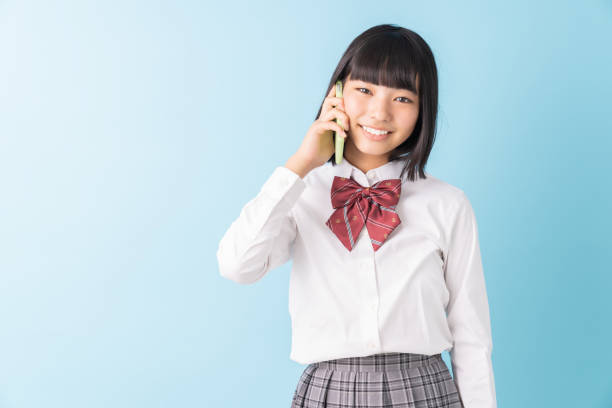 istock girl student who talks on the telephone,School uniform, 1298207843
