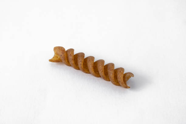 istock Uncooked Fusilli wholegrain pasta isolated on white background 1298209412