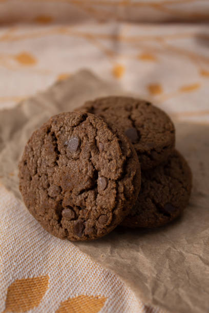 istock Stack of chocolate chip cookies on rustic paper 1298209442
