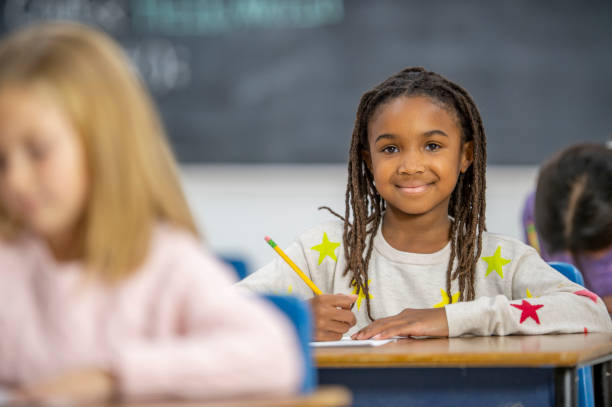 istock Smiling African school girl in class 1298212134