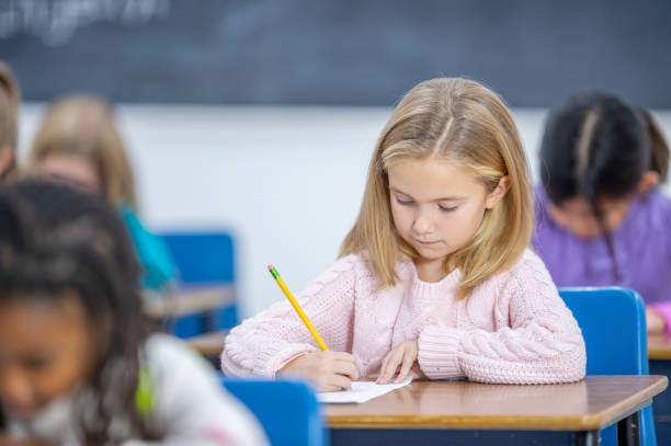 istock School girl writing at her desk in class 1298212143