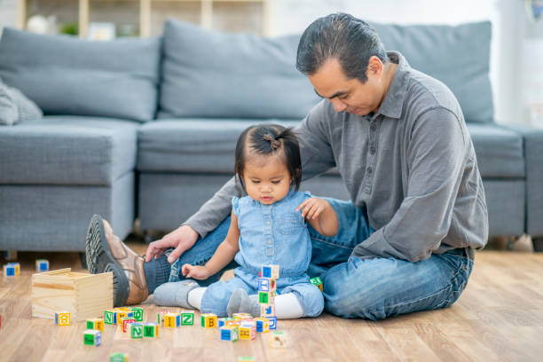 istock Father and daughter playing with blocks together 1298212434