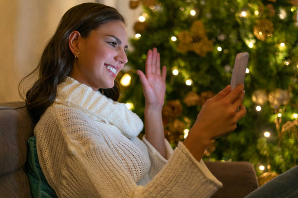 istock Latin woman makes a video call through her cell phone 1298215627