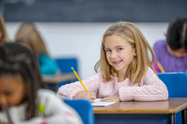 istock Adorable school girl in class 1298218287