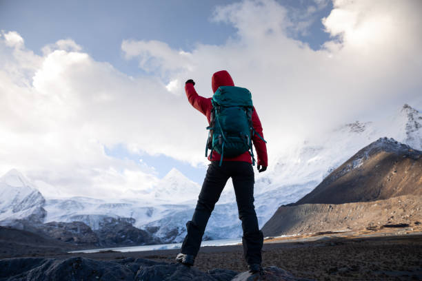 istock Strong woman backpacker hiking in winter mountains 1298221745