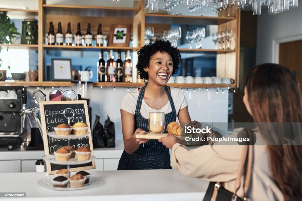 Good service goes a long way Shot of a young woman accepting a credit card payment while serving a customer in a cafe Small Business Stock Photo