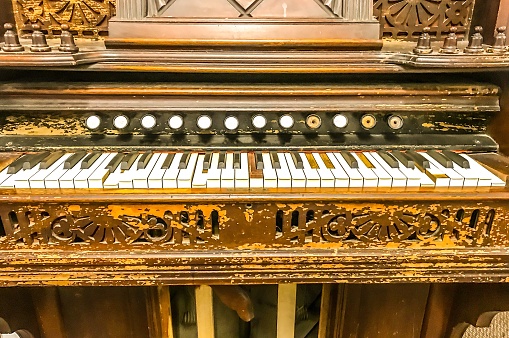 closeup of an old piano with music sheets in watercolor style