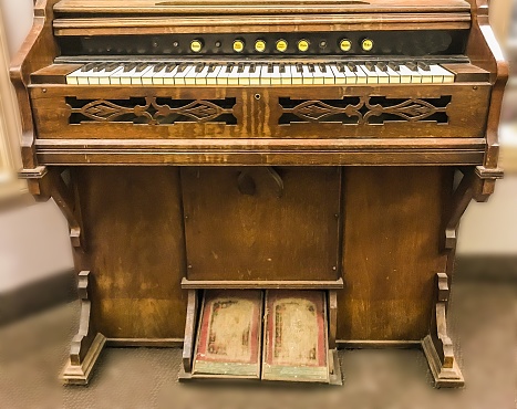Old wooden piano keys on wooden musical instrument in front view.