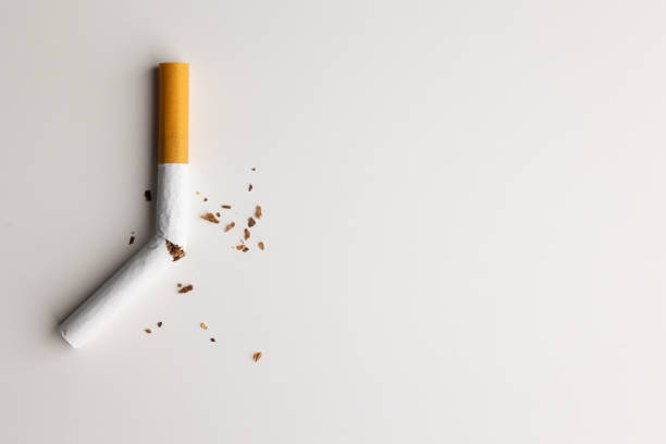 a broken cigarette on a white table visual content about quitting smoking. world tobacco day. - breaking cigarette imagens e fotografias de stock