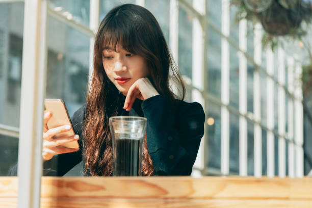 istock Woman Using Smart Phone At Coffee 1298235371