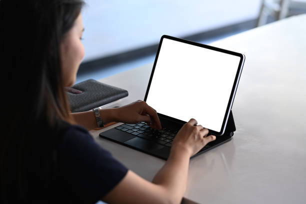 istock Rear view of female freelancer working on tablet computer while sitting at comfortable workplace. 1298242700