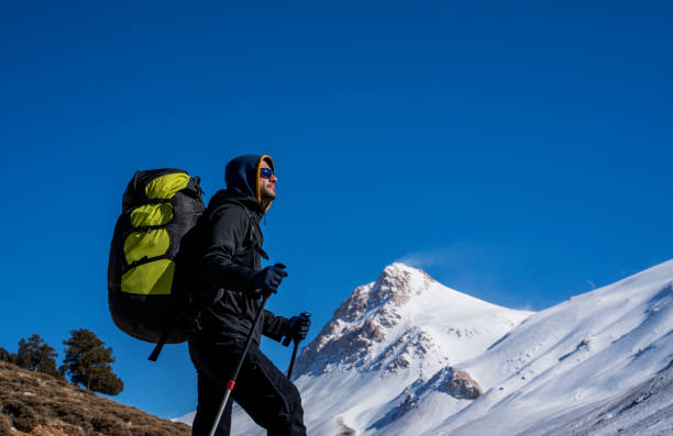 istock Man hiking on the mountains in winter with parachute backpack 1298243083