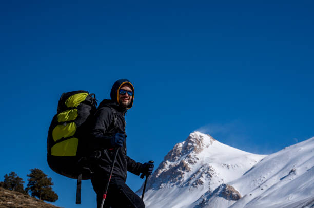 istock Man hiking on the mountains in winter with parachute backpack 1298243656