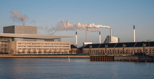 Cloud of smoke from the factory polluting the air during the bright sunny day