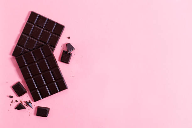 istock Dark chocolate bars on pink background, top view. 1298244901