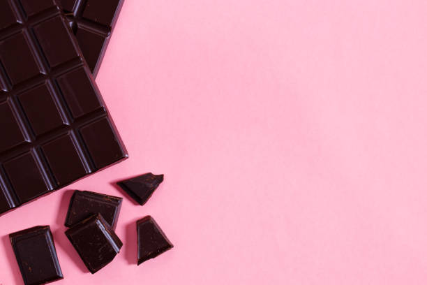 istock Dark chocolate bars on pink background, top view. 1298244905