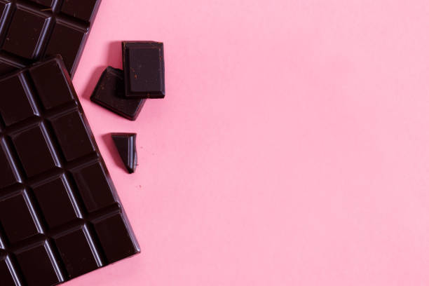 istock Dark chocolate bars on pink background, top view. 1298244919