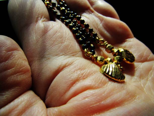 Religious Icons and Symbols A mangala sutra is a necklace that the groom ties around the bride's neck in Hinduism, during the marriage ceremony. Wearing it identifies her as a married woman. haldi ceremony stock pictures, royalty-free photos & images