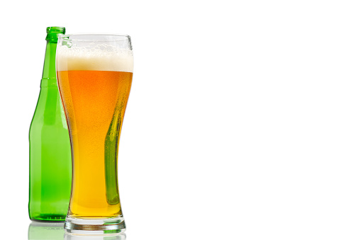 glass with beer and green bottle isolated on white, close-up