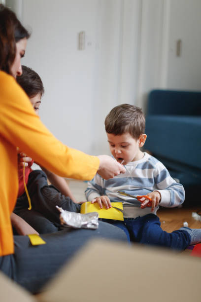 istock Mother playing with sons during house move and feeding them chocolate 1298245316