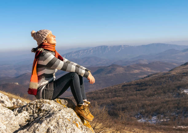 istock Woman hiker resting on cliff 1298246448