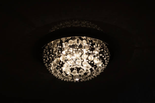 istock Large retro glass chandelier on ceiling in dark 1298246527