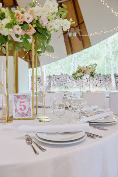 istock Table setting with white plate with napkin, cutlery and flowers on table, copy space. Place setting at wedding reception. Table served for banquet in restaurant 1298247972