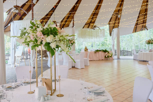 istock Table setting with lush bouquet of flowers on table, copy space. Place setting at luxury wedding reception. Round table and white chairs served for banquet in restaurant 1298247976