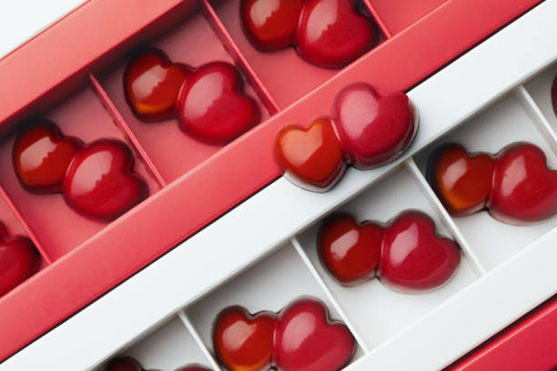 istock Craft dark chocolate candies in a double red double heart shape in boxes. Pattern. Sweet gift for valentines day 1298249562
