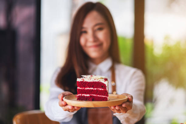 美しい若いアジアの女性、ウェイトレスやシェフが木製のトレイに赤いベルベットケーキを保持し、提供 - bread bakery women cake ストックフォトと画像