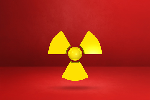 Radioactive symbol isolated on a red studio background. 3D illustration