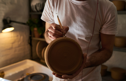 Shot of an unrecognisable man working with clay in a pottery studio