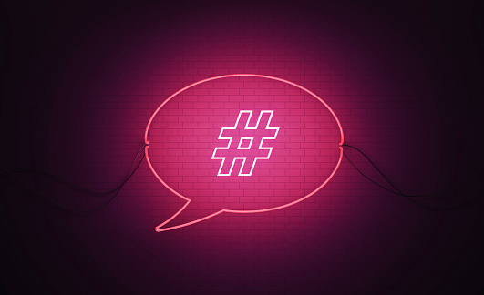 Speech Bubble Shaped Pink Neon Light With Hashtag Symbol On Black Wall - Online Messaging Concept