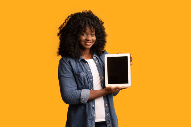 istock Pretty black woman showing digital tablet with blank screen 1298252435