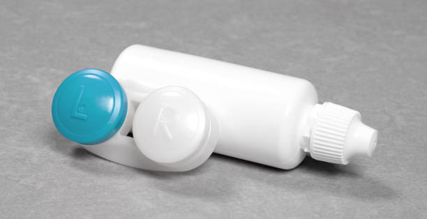 istock Blue contact lens case and bottle of solution, isolated on grey background 1298253826