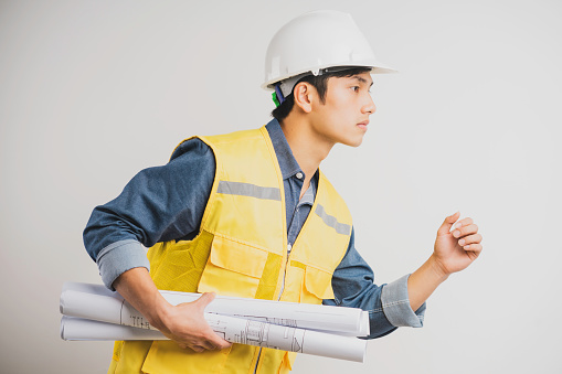 Asian construction engineer portrait holding the running drawing