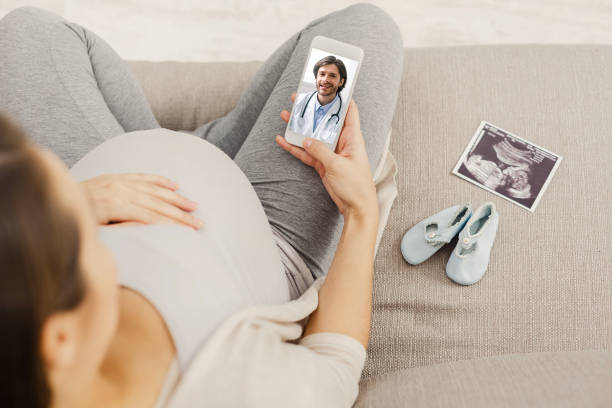 スマートフォンでビデオ通話を介して医師と相談妊娠中の女性患者 - human pregnancy ultrasound medical exam doctor ストックフォトと画像