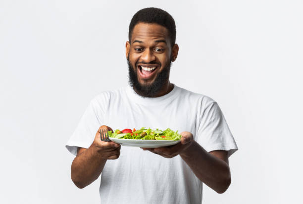 istock Excited African Bearded Guy Holding Salad Standing Over White Background 1298255366