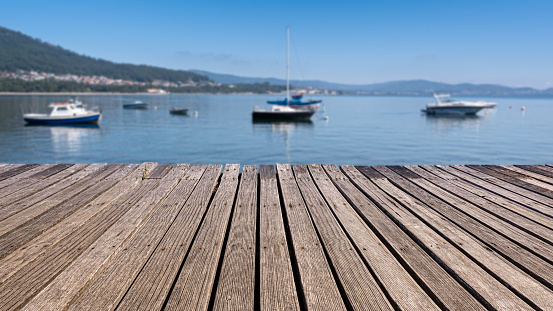 Sea landscape with mountains on the horizon and a wooden walkway in the foreground