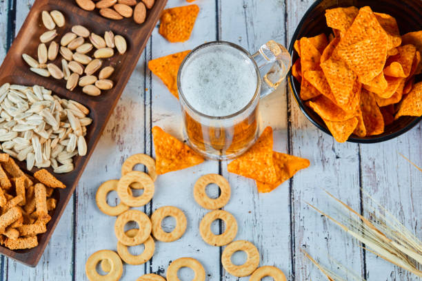 istock Assorted snacks, chips, and beer on blue table. Table for group of friends 1298255619