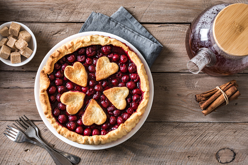 Homemade cherry pie on rustic wooden background, top view, copy space.