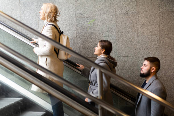 istock Side view of people moving up on escalator 1298256694