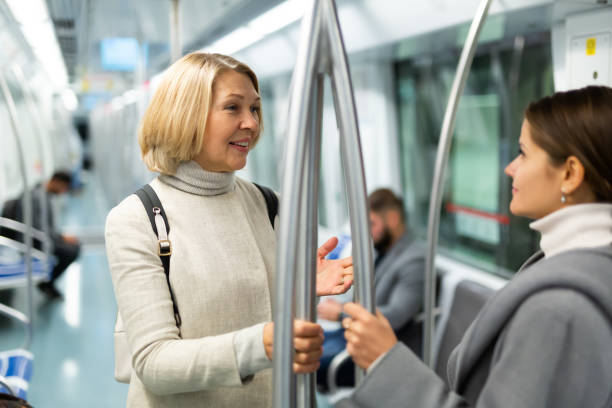 istock Two women passengers talking in subway car on way to work 1298256705