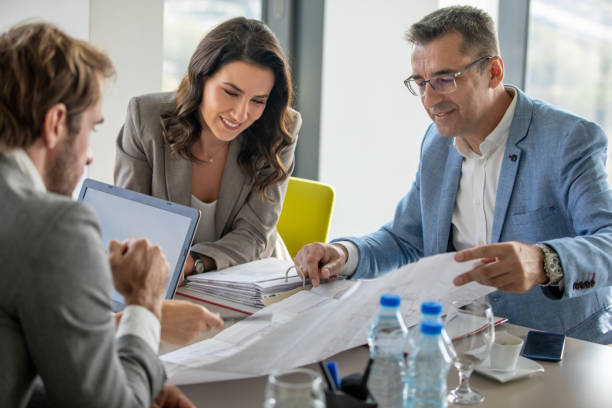 istock Managers at conference table discussing new project on spreadsheet 1298256860