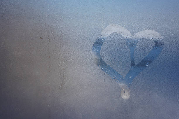 istock love heart on cold fogged window background, closeup image. a window with water drops 1298257216