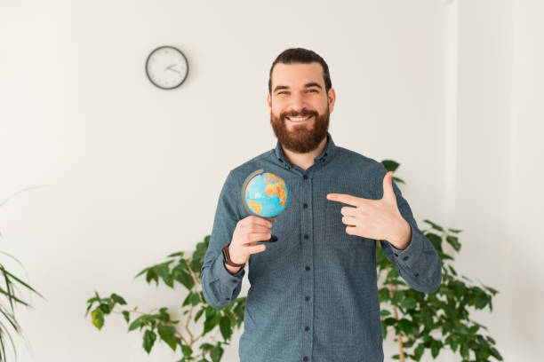 istock Photo of happy office worker pointing at globe 1298258158